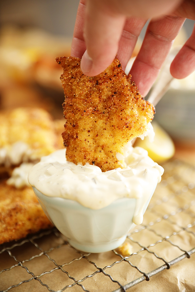 Piece of Fish being dipped into Dill Pickle Tartar Sauce
