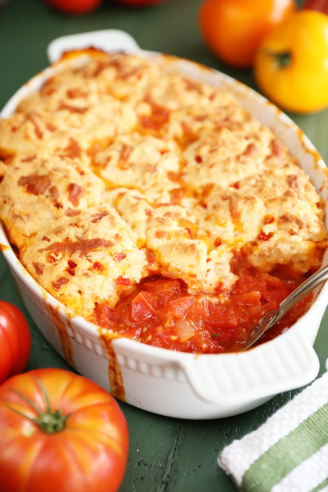 Baking dish with tomato cobbler topped with biscuits