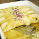 Creamy Chicken Enchiladas in a White Dish.