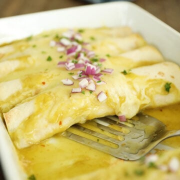 Creamy Chicken Enchiladas in a White Dish.