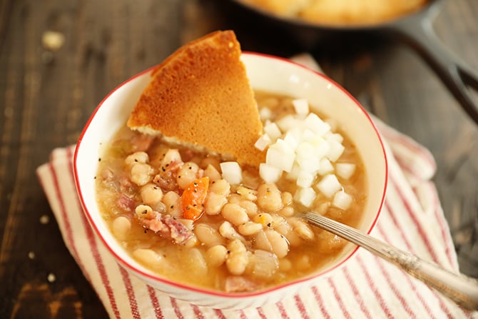 Slow Cooker Ham and Beans in bowl with cornbread and onions