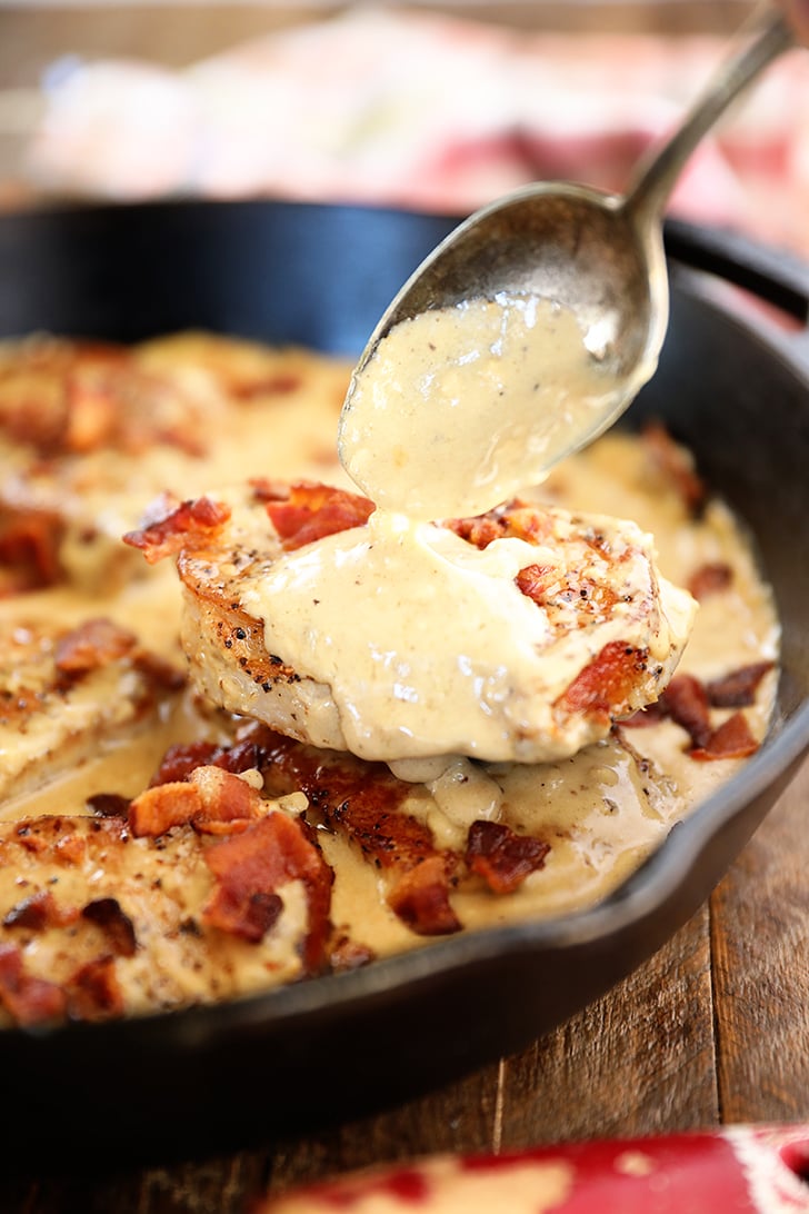 Sauce being poured over Pork Chops with Cream Bacon Pan Sauce in skillet