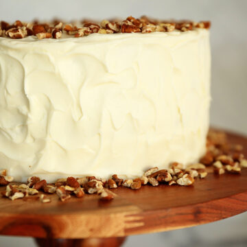 Whole carrot cake on cake stand.