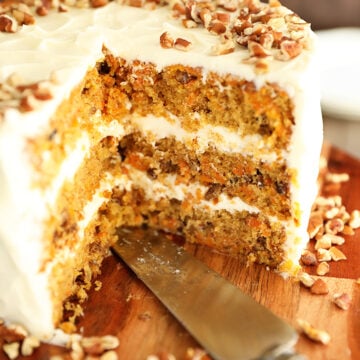 close up view of carrot cake with slices missing.