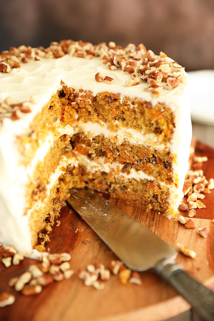 close up view of carrot cake with slices missing.
