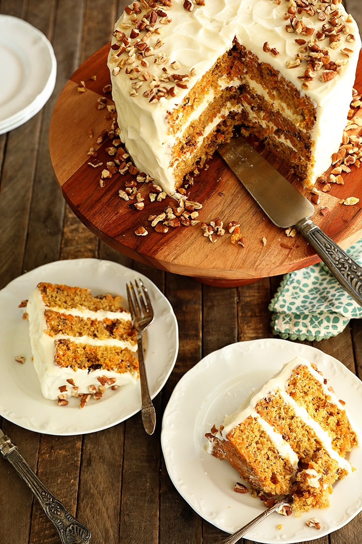 Carrot cake with slices missing and slices of cake on several plates.