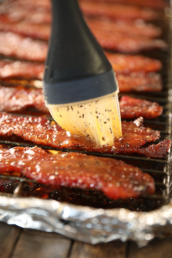 Brushing glaze on Easy Candied Bacon.