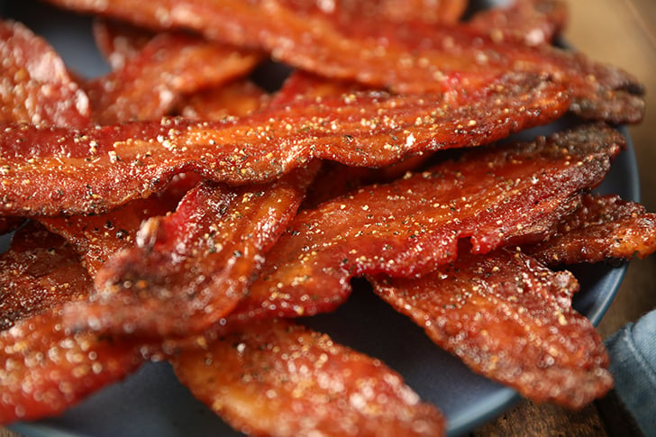 Easy Candied Bacon pieces on a blue plate.