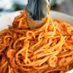 Tongs swirling 3-Ingredient Tomato and Boursin Pasta in a bowl.