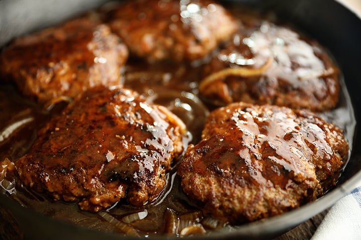 Salisbury Steaks in a skillet.