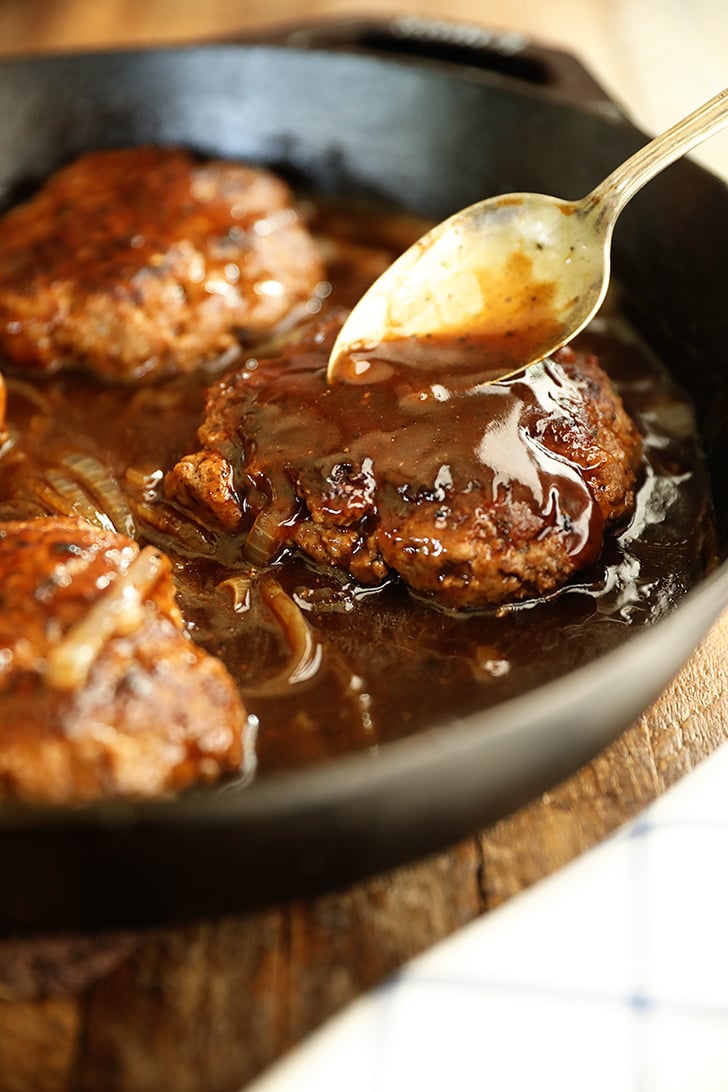 Gravy being poured over Salisbury Steak.