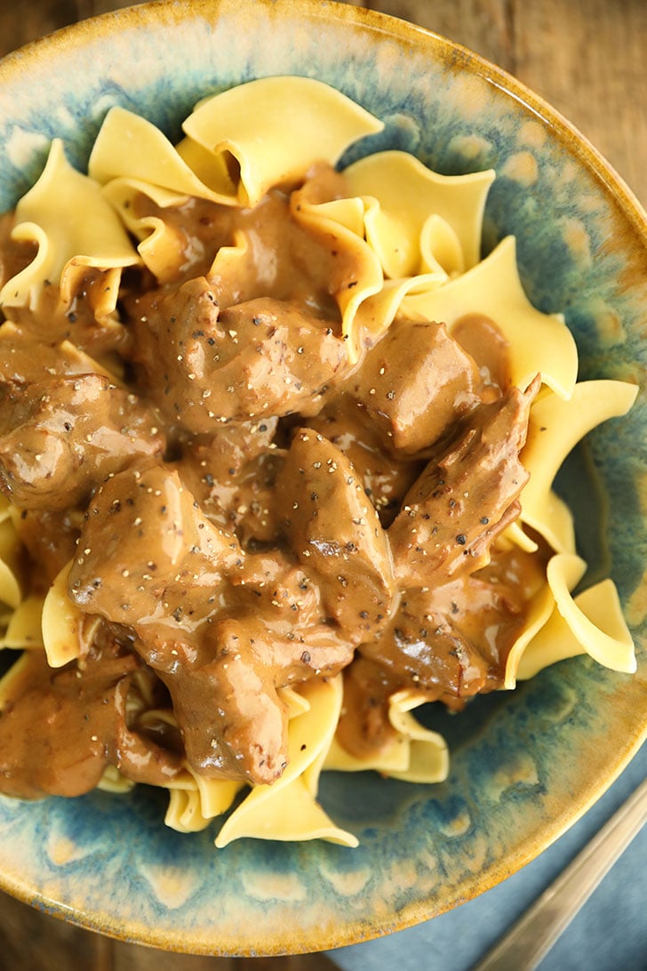 Slow Cooker Beef Stroganoff in a bowl over noodles.