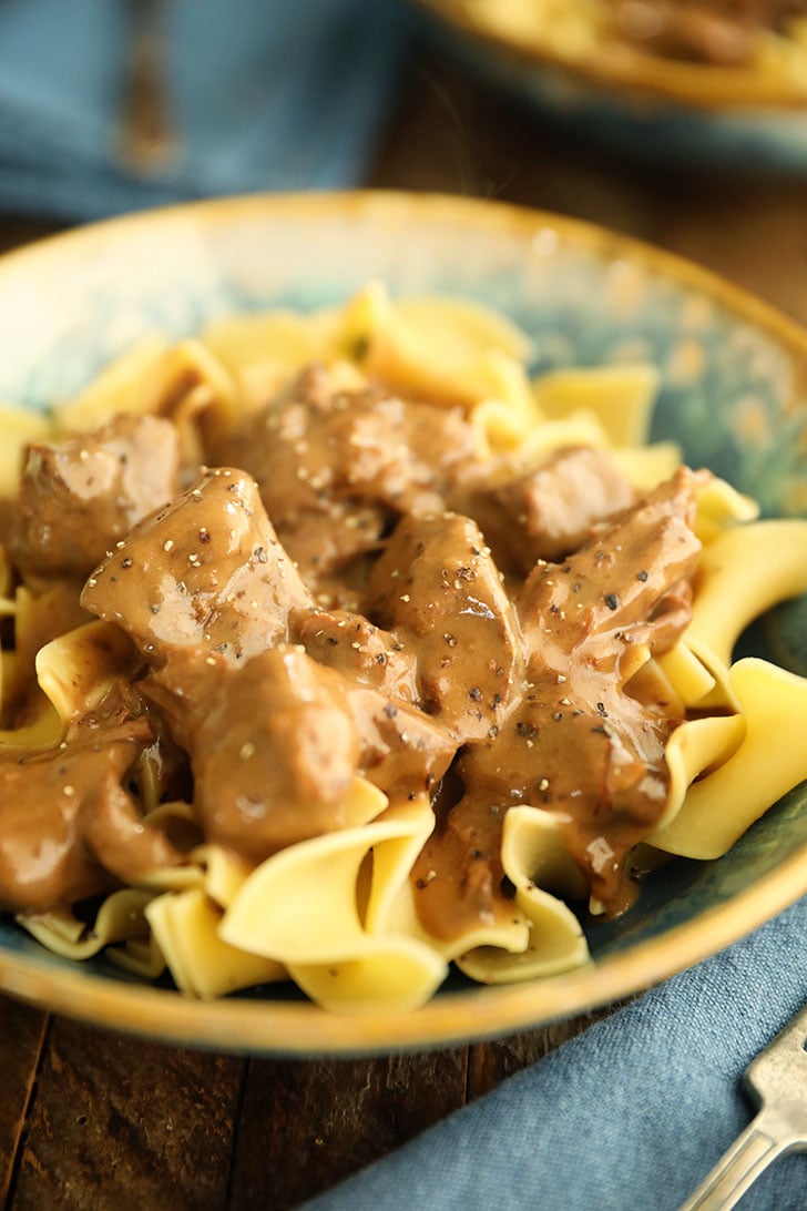 Slow Cooker Beef Stroganoff in a bowl over noodles.