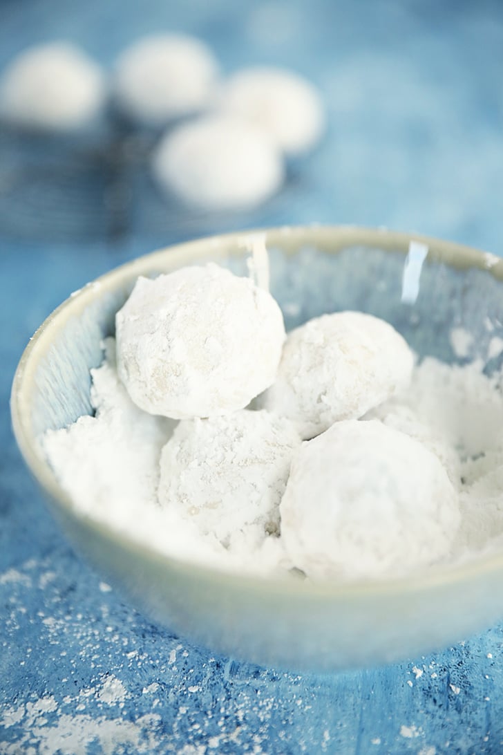 Pecan Snowball Cookies in a bowl of sugar.