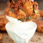 Fried Pickle Fritter being dipped in ranch.