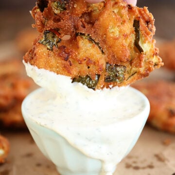 Fried Pickle Fritter being dipped in ranch.