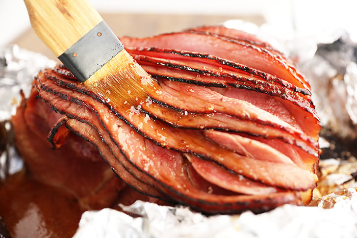 Brown Sugar Pineapple Ham Glaze being brushed over ham.