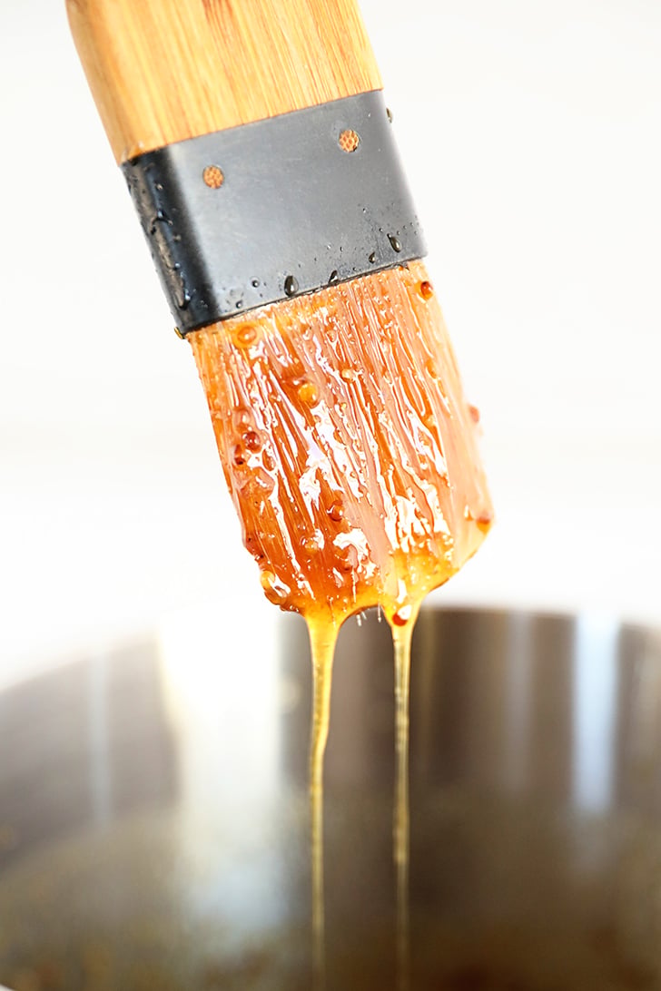 Brown Sugar Pineapple Ham Glaze dripping off brush.