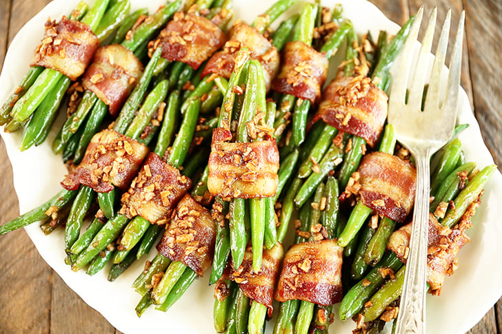 Green Bean Bundles stacked on white plate.