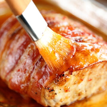 Brushing pepper jelly glaze on pork loin.