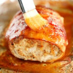 Brushing pepper jelly glaze on pork loin.