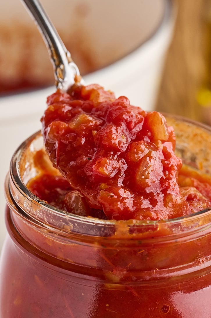 Spoonful of Homemade Marinara Sauce in a jar.