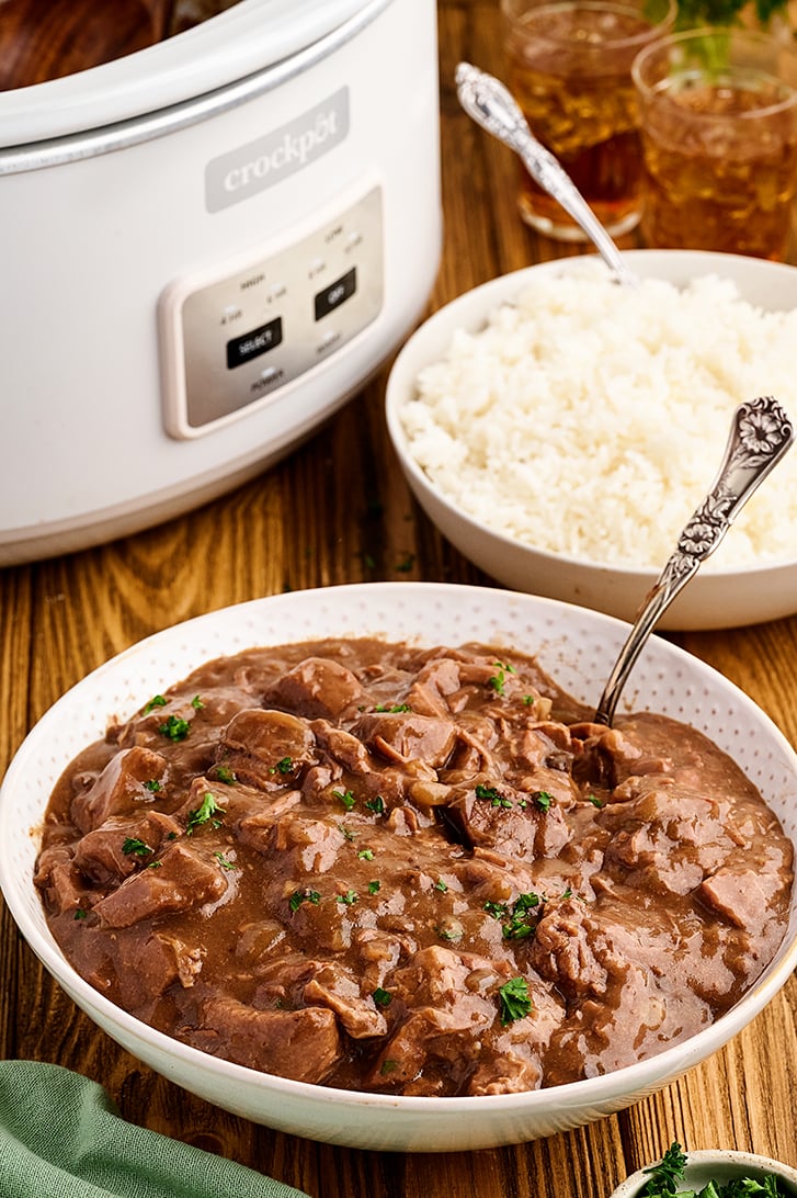 Slow Cooker Beef Tips and Rice with slow cooker in background.