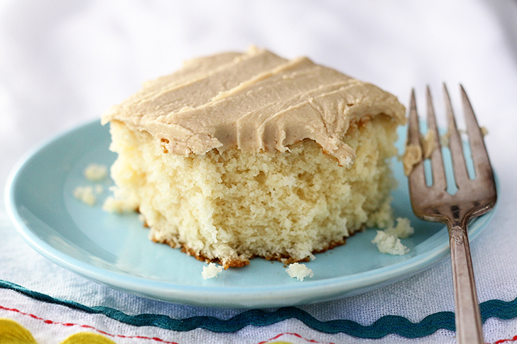 Easy Caramel Sheet Cake on a blue plate. bite missing.