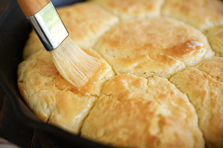 Brushing butter on biscuits.