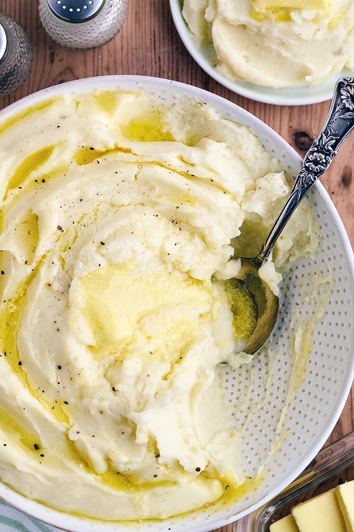 Bowl with Cream Cheese Mashed Potatoes with butter on top.