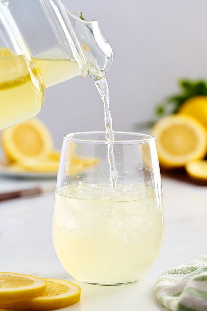 Pouring lemonade into a glass.
