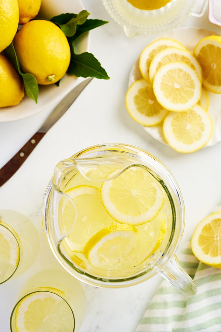 Overhead view of lemonade in pitcher with lemons.