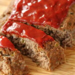 Sliced meatloaf on a cutting board.