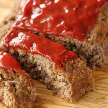 Sliced meatloaf on a cutting board.