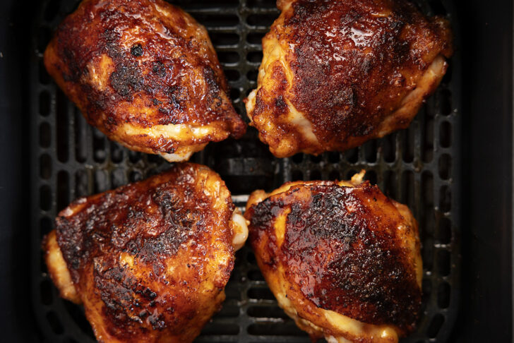 Chicken thighs in an air fryer with hot honey glaze.