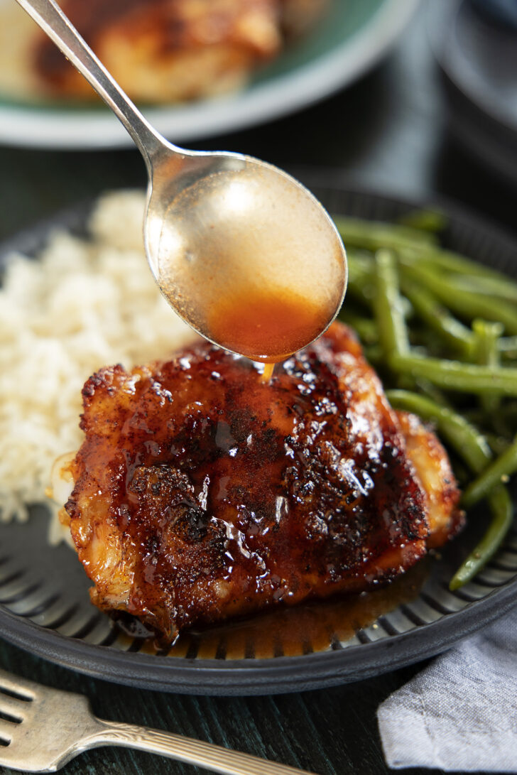 Air fryer chicken thigh on a plate with hot honey glaze.